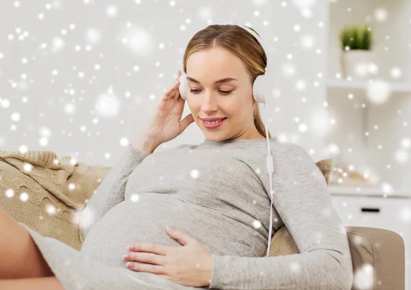 Mujer embarazada con auriculares escuchando música — Foto de Stock