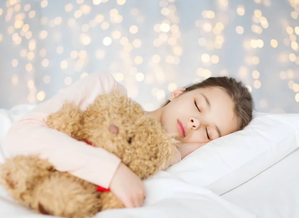 Chica durmiendo con osito de peluche juguete en cama —  Fotos de Stock