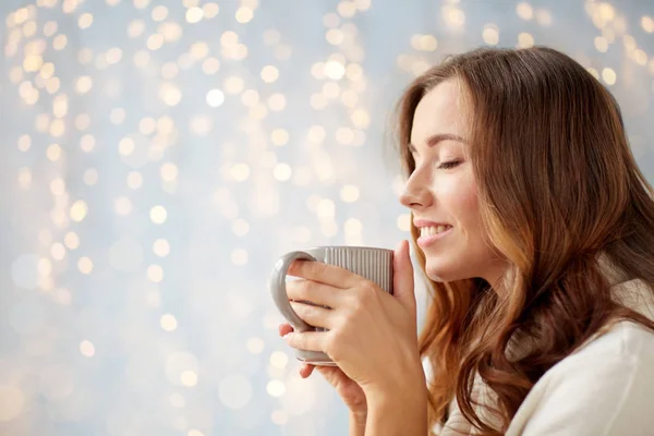 Щаслива жінка з чашкою чаю або кави вдома — стокове фото