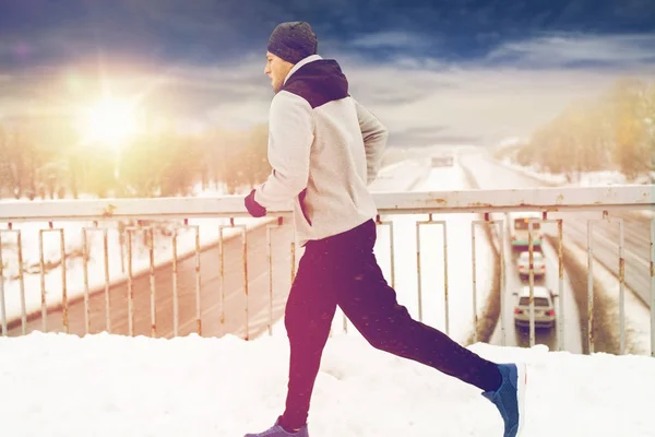 Mann läuft auf schneebedeckter Winterbrücke — Stockfoto