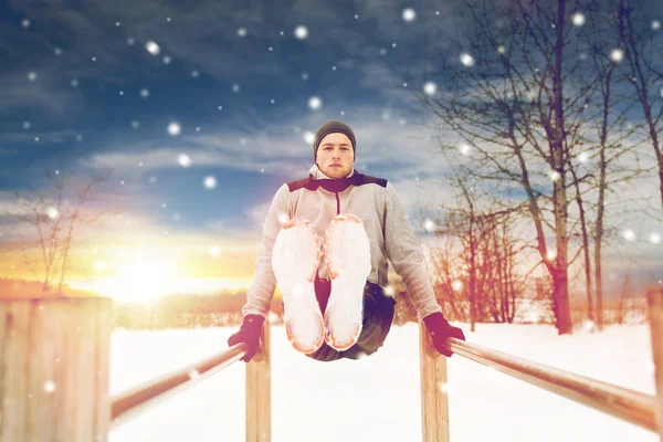 Jovem exercitando-se em barras paralelas no inverno — Fotografia de Stock