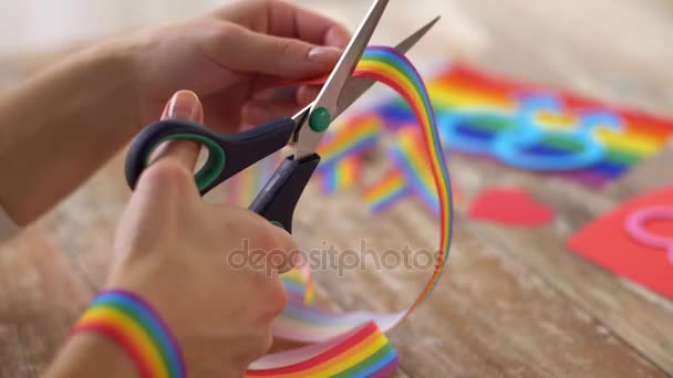 Hände mit der Schere schneiden Gay Pride Awareness Bändchen — Stockvideo