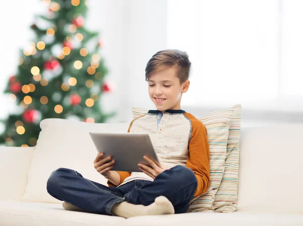 Uśmiechnięty chłopiec z komputera typu tablet w domu na Boże Narodzenie — Zdjęcie stockowe