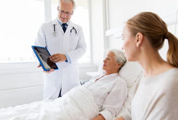 Mujer mayor y médico con tableta pc en el hospital — Foto de Stock