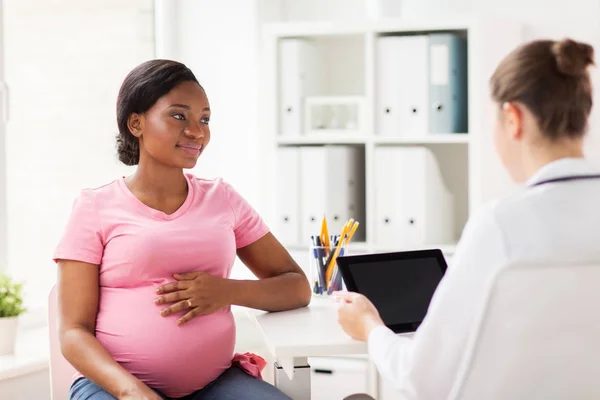 Medico con tablet pc e donna incinta in clinica — Foto Stock