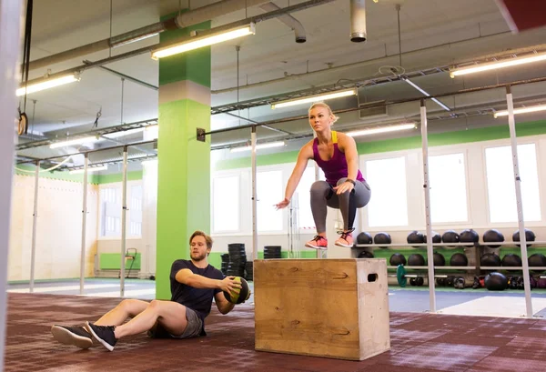 Mujer y hombre con balón de medicina haciendo ejercicio en el gimnasio — Foto de Stock
