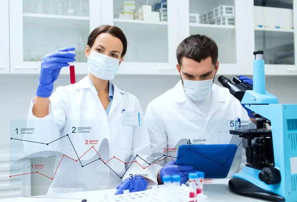 Cientistas com tubos de ensaio que fazem pesquisa em laboratório — Fotografia de Stock