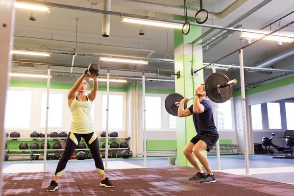 Mann und Frau mit Gewichten trainieren im Fitnessstudio — Stockfoto
