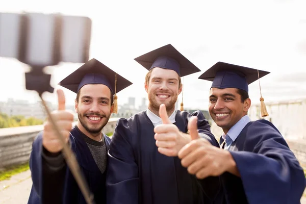 Glückliche männliche Studenten oder Absolventen beim Selfie — Stockfoto