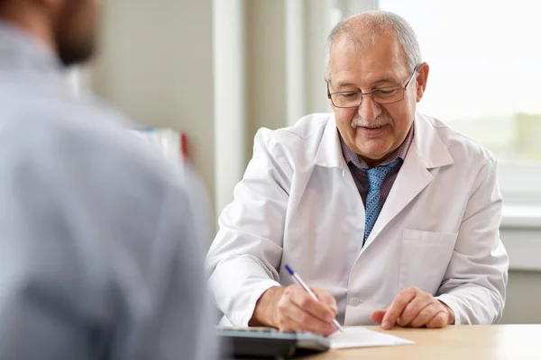 Médico escribiendo prescripción para el paciente en la clínica — Foto de Stock