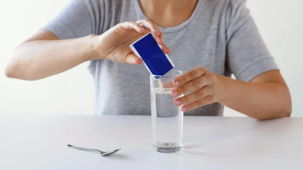 Femeia care toarnă medicamente în pahar cu apă — Fotografie, imagine de stoc