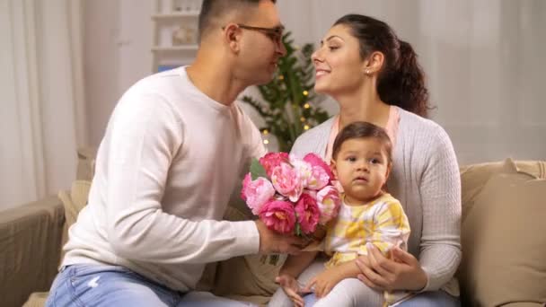 Familia feliz con la niña y las flores en casa — Vídeo de stock