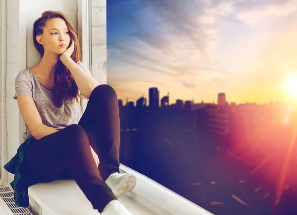 Triste chica adolescente bonita sentada en el alféizar de la ventana —  Fotos de Stock