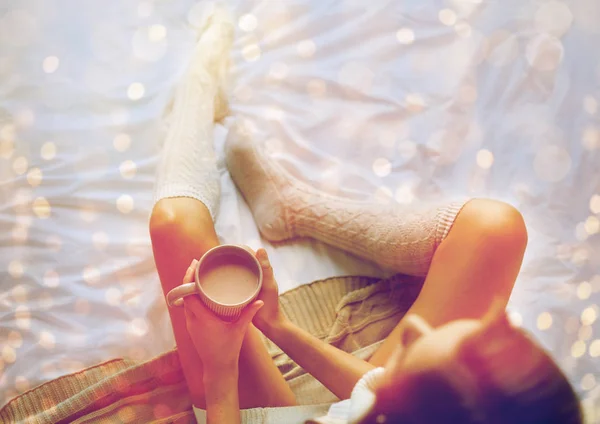 自宅のベッドでココアのカップを持つ女性のクローズ アップ — ストック写真