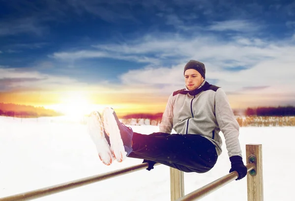 Junger Mann trainiert im Winter am Barren — Stockfoto