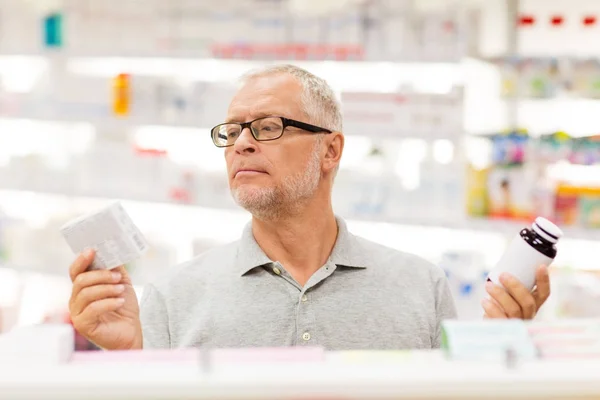 Senior male customer choosing drugs at pharmacy — Stock Photo, Image