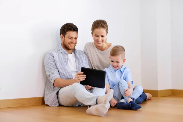 Happy family with tablet pc moving to new home — Stock Photo, Image