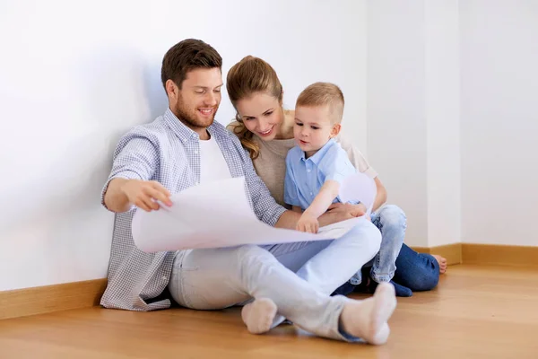Happy family with blueprint moving to new home — Stock Photo, Image