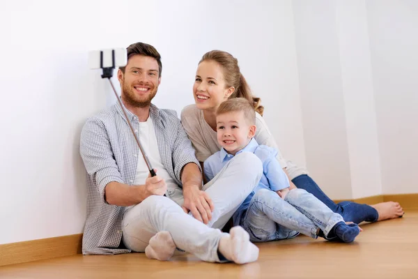 Familia tomando selfie por teléfono inteligente en un nuevo hogar — Foto de Stock