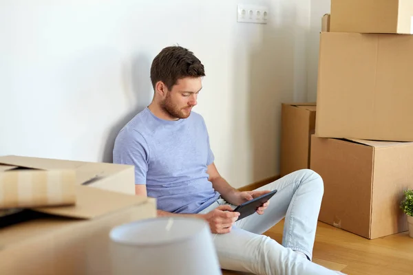 Hombre con la PC tableta y cajas que se mueven a nuevo hogar —  Fotos de Stock
