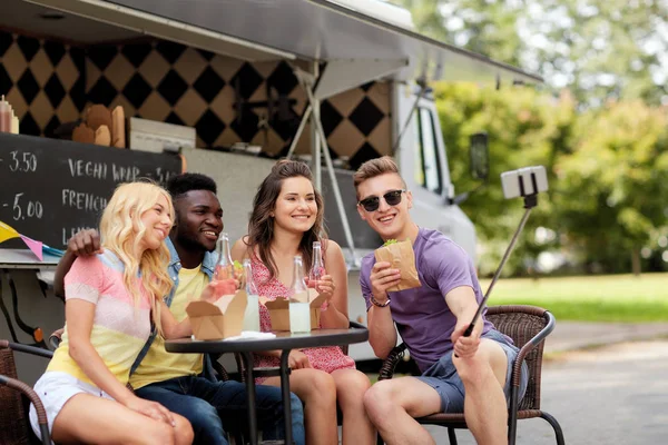 Felices jóvenes amigos tomando selfie en camión de comida — Foto de Stock