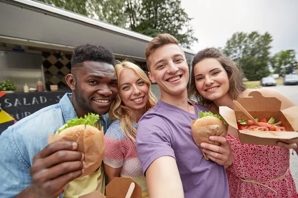 Amigos felices tomando selfie en camión de comida — Foto de Stock
