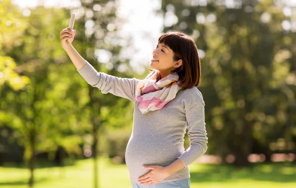 快乐怀孕的亚洲妇女在公园自拍 — 图库照片