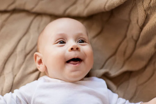 Süßer kleiner Junge liegt auf Strickdecke — Stockfoto