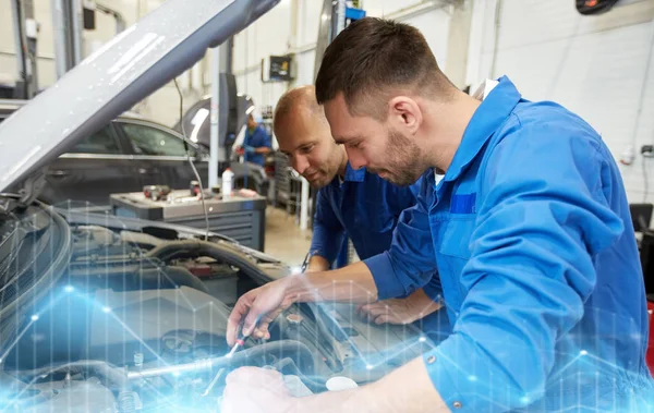 Hombres mecánicos con llave inglesa reparación de coches en el taller —  Fotos de Stock