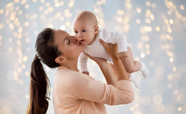 Glückliche Mutter küsst kleinen Jungen über Lichter — Stockfoto