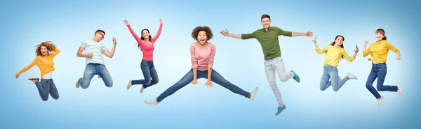 Gente feliz o amigos saltando en el aire sobre azul — Foto de Stock