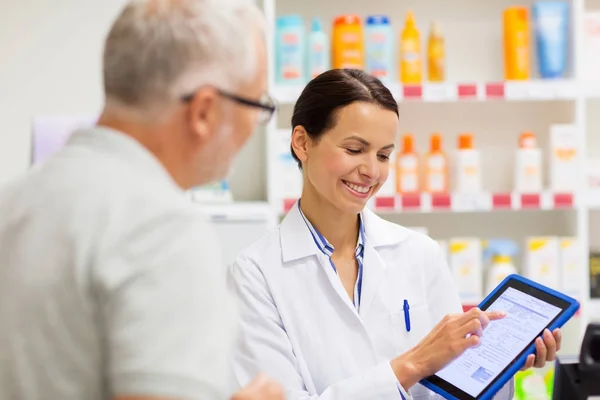 Boticario y cliente con tableta PC en la farmacia — Foto de Stock