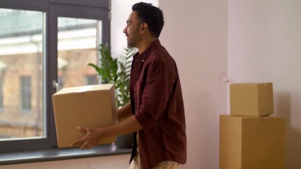 Homem feliz com caixa se movendo para nova casa e dança — Vídeo de Stock
