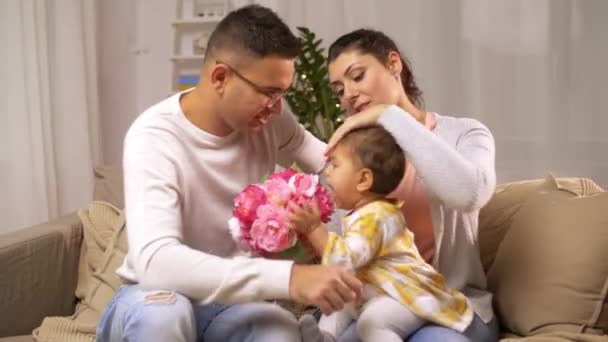 Ευτυχισμένη οικογένεια με κοριτσάκι και λουλούδια στο σπίτι — Αρχείο Βίντεο