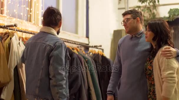 Amigos escolhendo roupas na loja de roupas vintage — Vídeo de Stock