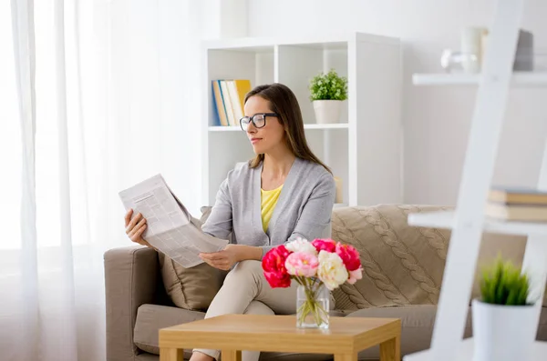 Glückliche Frau, die zu Hause Zeitung liest — Stockfoto