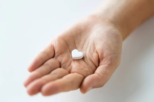 Közelkép a kezében gyógyszer szív tabletta — Stock Fotó