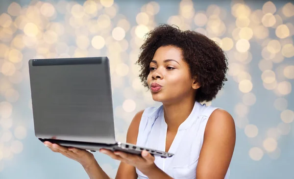 Mulher com computador portátil enviando beijo a alguém — Fotografia de Stock
