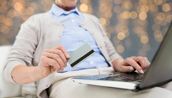 Mulher sênior com laptop e cartão de crédito — Fotografia de Stock
