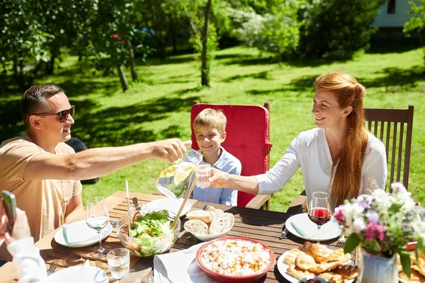 Mutlu bir aile yemek yiyor ya da bahçe partisi veriyor. — Stok fotoğraf