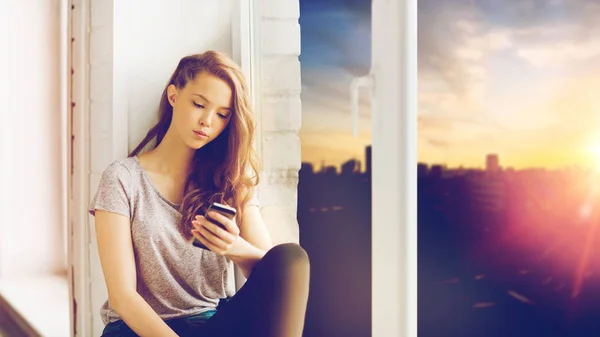 Грустная девушка-подросток со смартфоном — стоковое фото