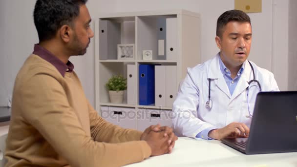 Doctor with laptop and male patient at hospital — Stock Video