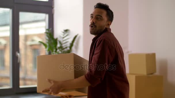 Happy man with box moving to new home and dancing — Stock Video