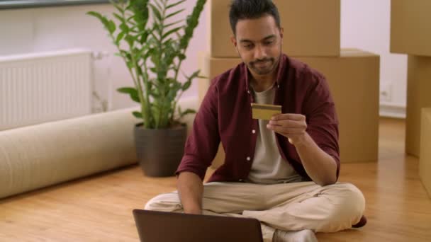 Человек с ноутбуком покупает онлайн в новом доме — стоковое видео