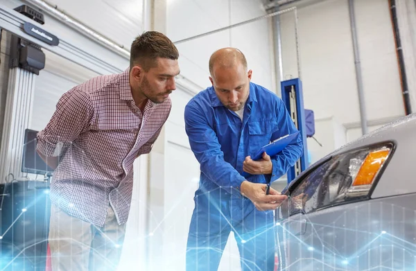 Auto mechanic with clipboard and man at car shop — Stock Photo, Image