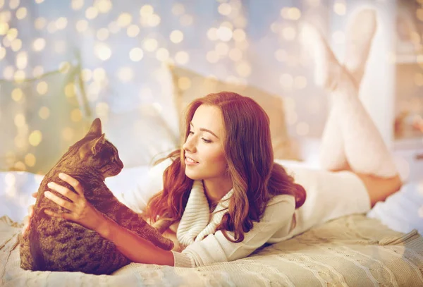 집에서 침대에 누워 있는 고양이 함께 행복 한 젊은 여자 — 스톡 사진