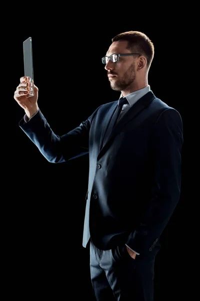 Homem de negócios em terno trabalhando com tablet transparente pc — Fotografia de Stock