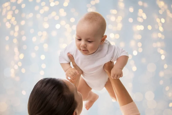Gelukkig moeder spelen met kleine babyjongen over verlichting — Stockfoto