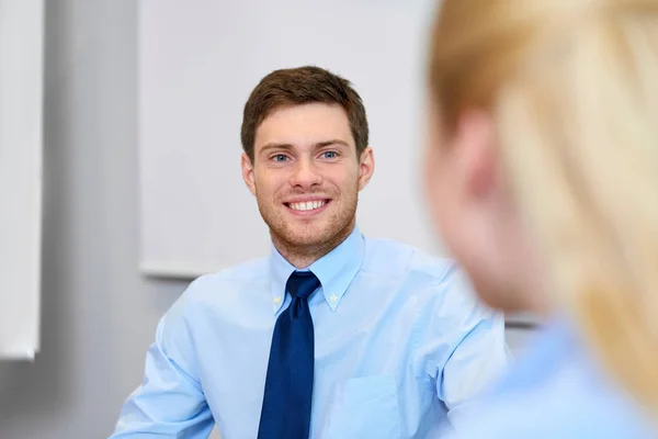 Бизнесмен разговаривает с коллегой-женщиной в офисе — стоковое фото