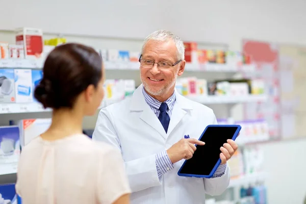 Speziale e cliente con tablet pc in farmacia — Foto Stock